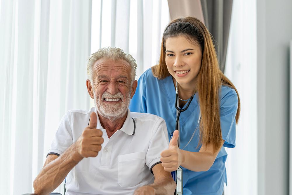 Man being cared for by a private Asian nurse at home suffering from Alzheimer's disease to closely care for elderly patients with copy space on left