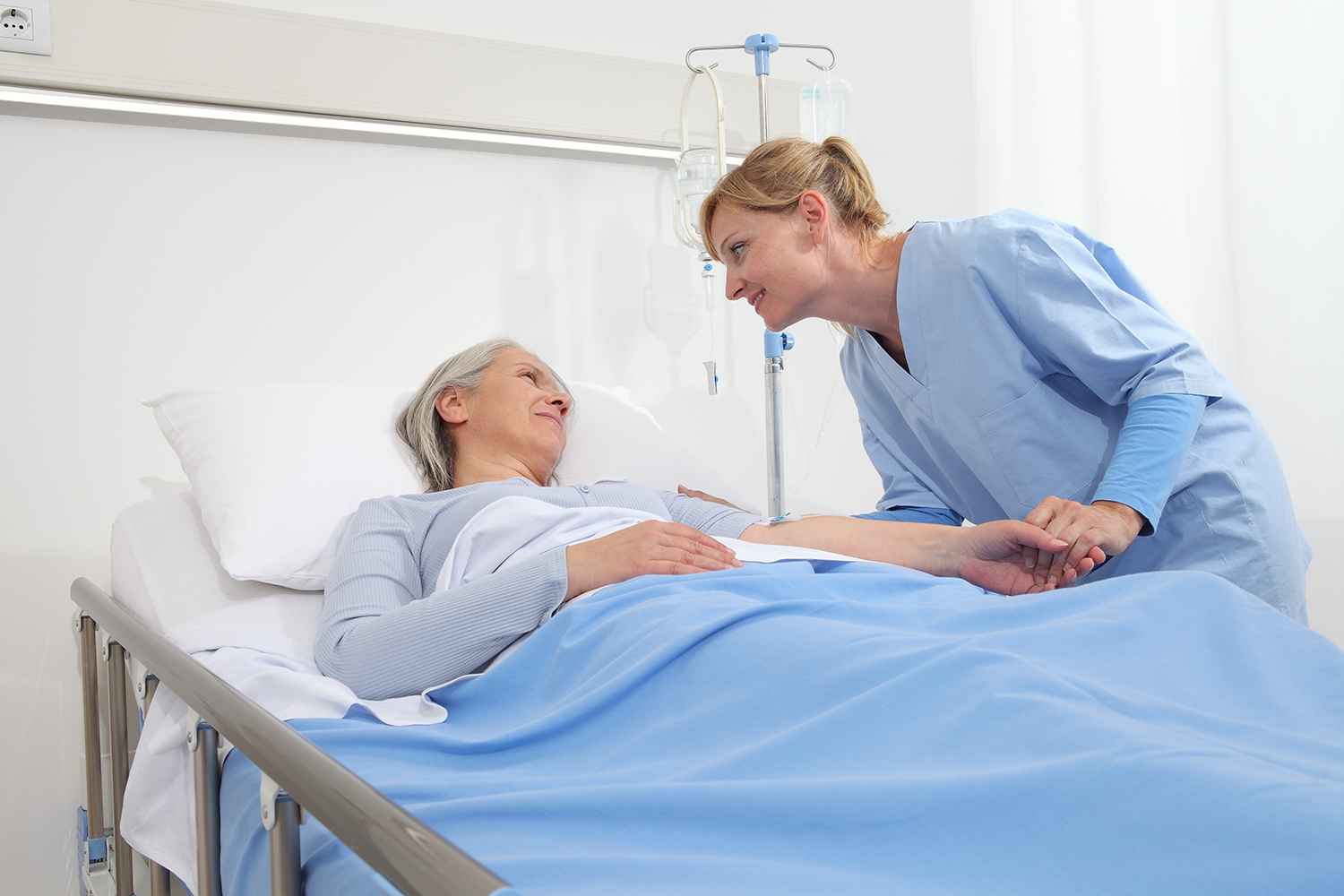 nurse take comfort elderly woman lying in the hospital room bed, by stroking her and holding the arm where the drip needle is, concept of loneliness and old age diseases